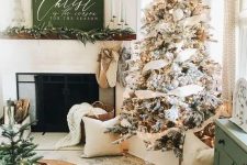 farmhouse and woodland Christmas decor with a flocked Christmas tree with neutral decor, stockings and evergreens