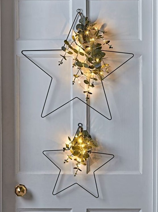 Metal star shaped Christmas wreaths with evergreens, eucalyptus and lights are a great decor idea for a Scandi or modern space