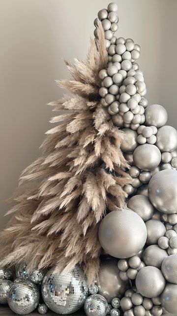A jaw dropping Christmas tree composed of pampas grass and silver ornaments plus some silver disco balls at the base