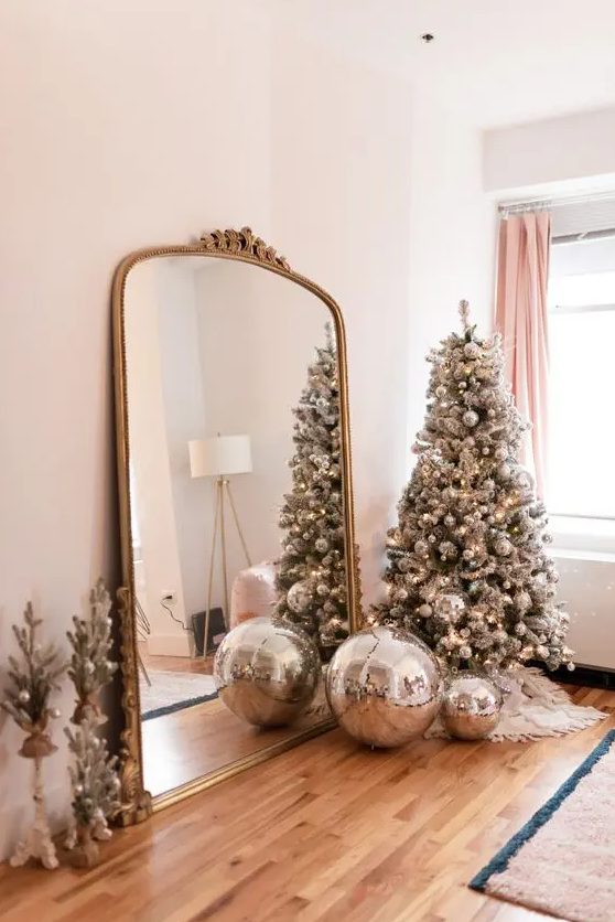 a silver Christmas tree fully decorated with silver disco balls is a super cool and fresh decor idea for a NYE party