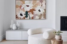 17 a pretty neutral living room with a creamy boucle sofa, a wood side table, a muted color artwork