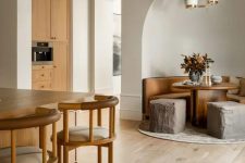 20 an earthy eclectic space with light and rich-stained furniture, poufs that resemble of rocks, a stained wooden ceiling