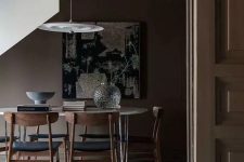 23 a moody all-taupe dining space with a neutral floor, an oval hairpin leg table, black chairs and a pendant lamp