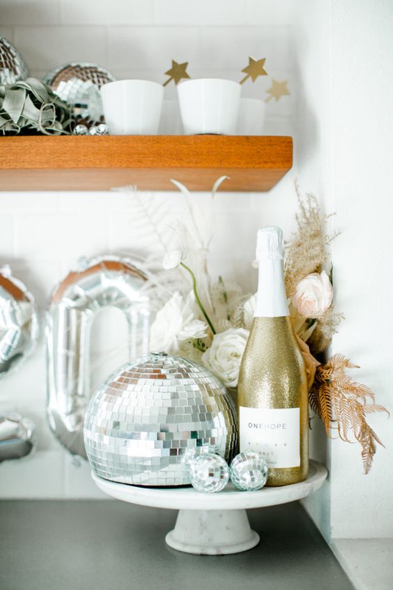 disco ball NYE decor with leaves and silver balloons is ideal for a NYE party