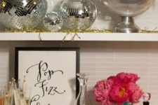 28 silver disco balls and bold pink blooms plus gold tinsel will make your NYE party fun, bold and cool