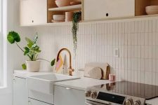 33 a chic kitchen in dove grey and light-colored plywood, with white countertops and a white stacked tile backsplash