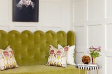 43 a beautiful English chic space with paneled walls, a chartreuse loveseat, a coffee table and printed pillows