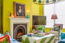 44 a colorful and eclectic living room with chartreuse walls, a fireplace, a bold printed ottoman, navy chairs and a sofa, a catchy chandelier