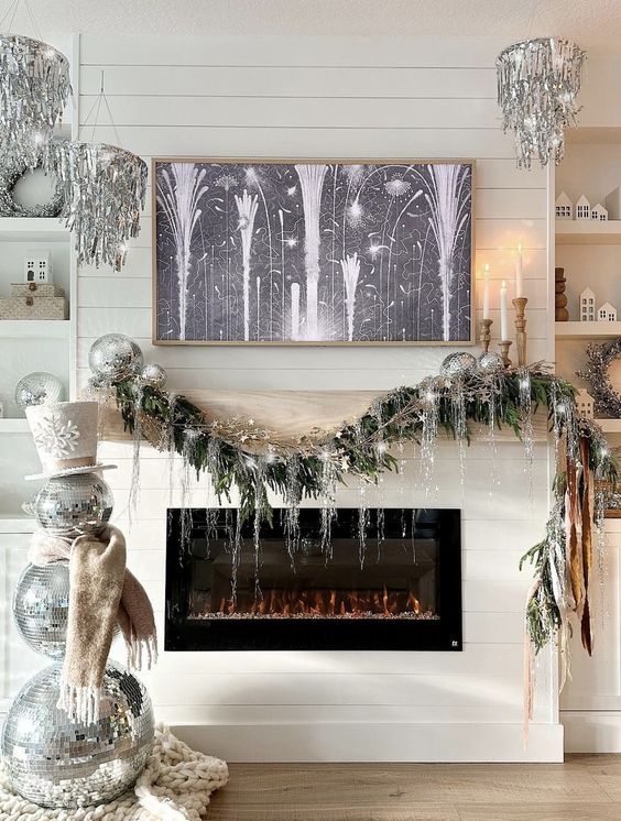 NYE party decor with silver tinsel chandeliers, a disco ball snowman and a garland with disco balls and silver fringe