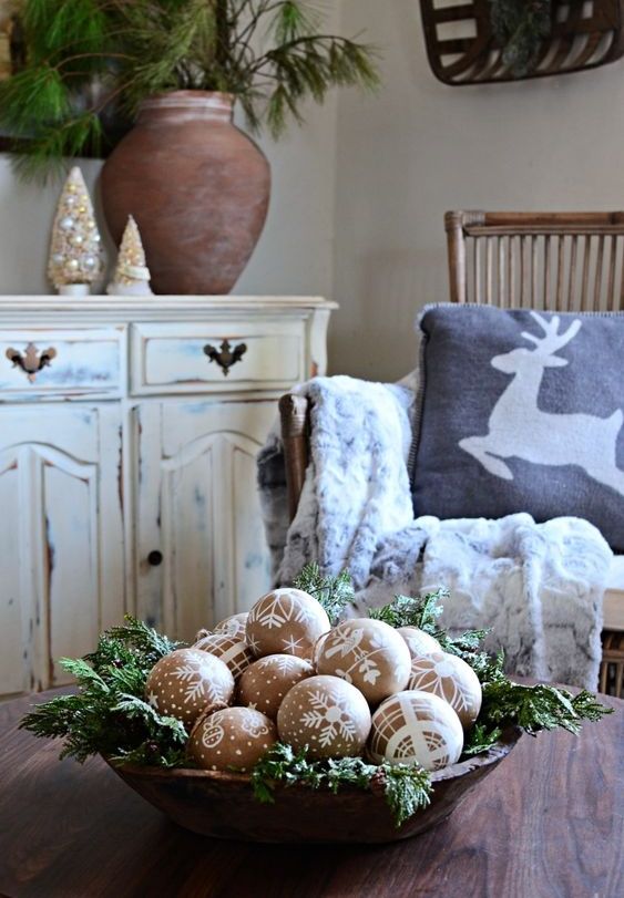 a Christmas arrangement of a wooden bowl with evergreens, cardboard ornaments with patterns is a cool idea