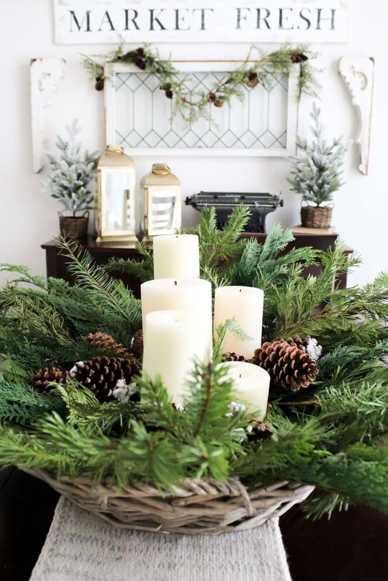 a Christmas bowl with evergreens, pillar candles and pinecones is a lovely rustic centerpiece for the holidays