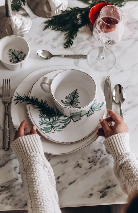a Christmas tablescape with printed porcelain, glasses, evergreens and candleholders is simple and cute