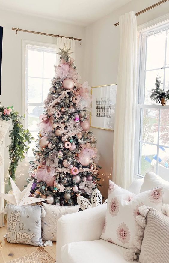 a Christmas tree styled with pastel pink ornaments and some mauve ones, donuts, houses and tulle bows is very glam
