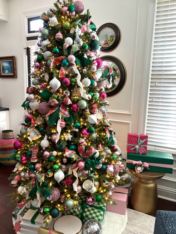 a Christmas tree styled with ribbon, pink and green ornaments and lights is a super chic and cool idea