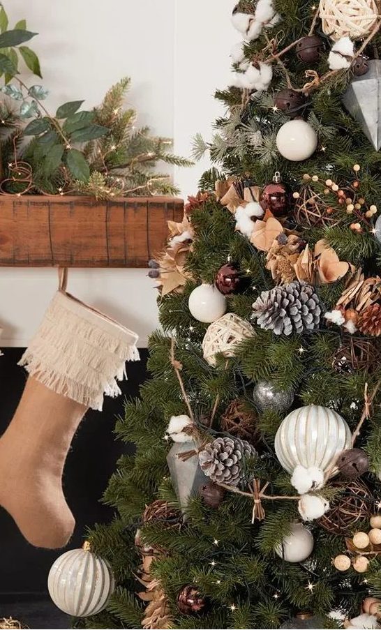 a Christmas tree with lights, brown, silver and white ornaments, wooden beads, snowy pinecones, cotton and bells is a great idea for both a rustic or a forest celebration