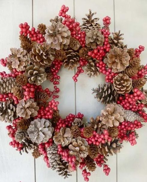 a Christmas wreath of bleached and usual pinecones and cranberries is a cool and bold decor idea for the holidays, and it's not difficult to make