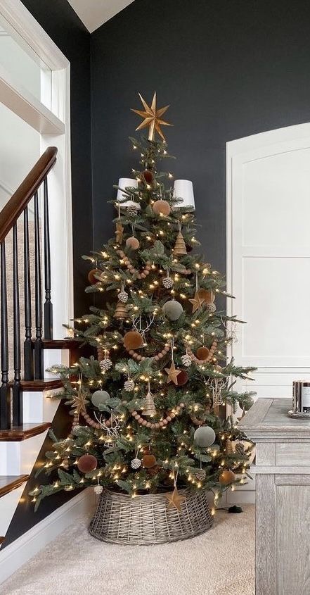 a beautiful farmhouse Christmas tree with lights, wooden beads, olive green and brown velvet ornaments and stars