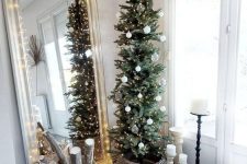 a beautiful slim Christmas tree with white and sheer ornaments and lights in a basket is a cool and catchy idea