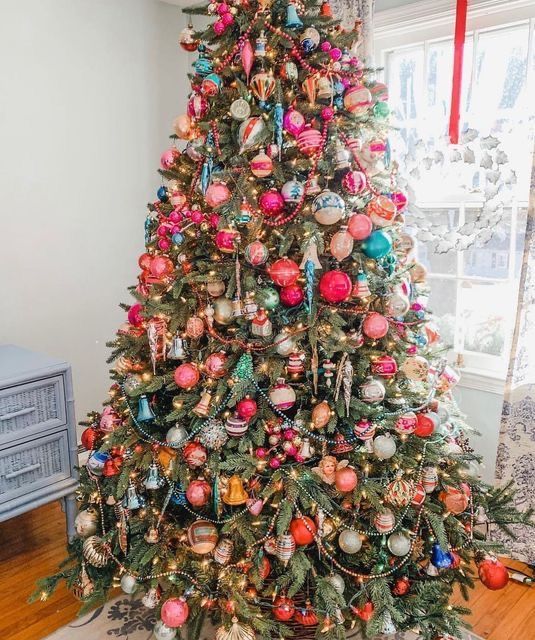 a bold Christmas tree covered with bright ornaments, beads and lights is a super cool and catchy decoration