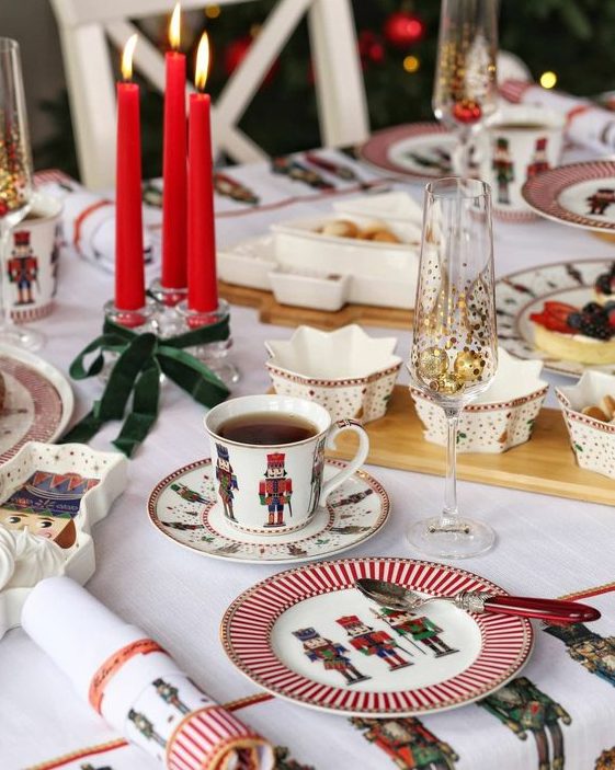 a bright Christmas tablescape with printed porcelain, red candles, star-shaped bowls and printed textiles