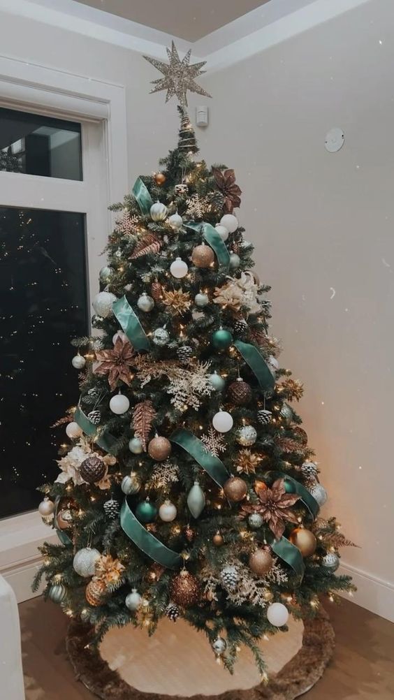 a catchy Christmas tree with green ribbons, white snowflakes and faux blooms, white and brown ornaments, pinecones and lights