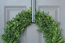a catchy Christmas wreath of boxwood, with a striped ribbon will match many styles and decor themes