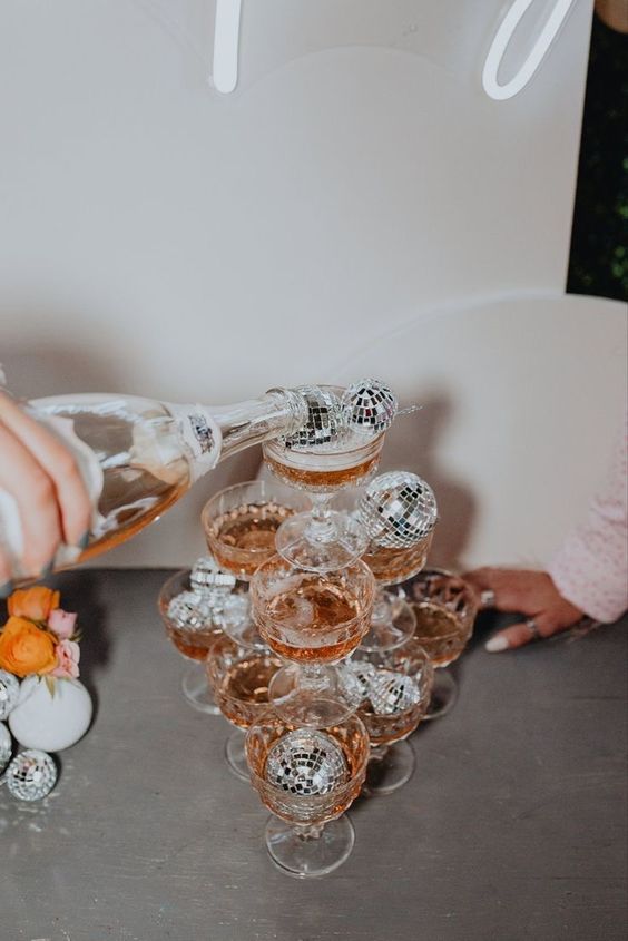 a champagne tower made with disco balls is a super fun and cool idea for a NYE party, make one easily