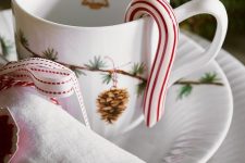 a chic Christmas setting with white procelain printed, white napkins, a candy cane and a napkin