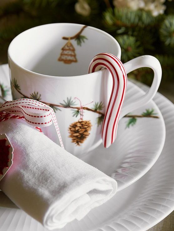 a chic Christmas setting with white procelain printed, white napkins, a candy cane and a napkin