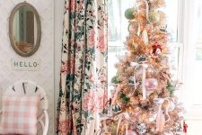 a chic Christmas tree styled with pastel green and pink ornaments, with ribbon bows and a gold star topper