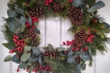 a classic rustic Christmas wreath of evergreens, eucalyptus, red berries and pinecones is a lovely decoration