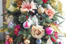 a colorful Christmas tree with bold bauble and cupcake ornaments, flowers and feathers is amazing