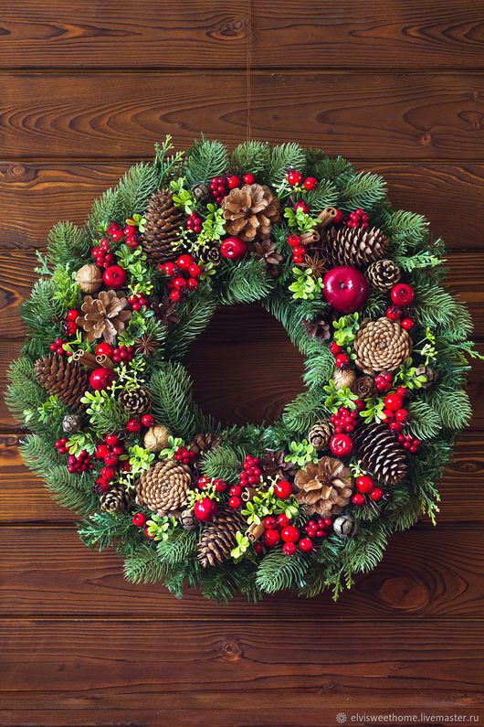 a colorful rustic Christmas wreath of evergreens, berries, blooms, pinecones and other stuff