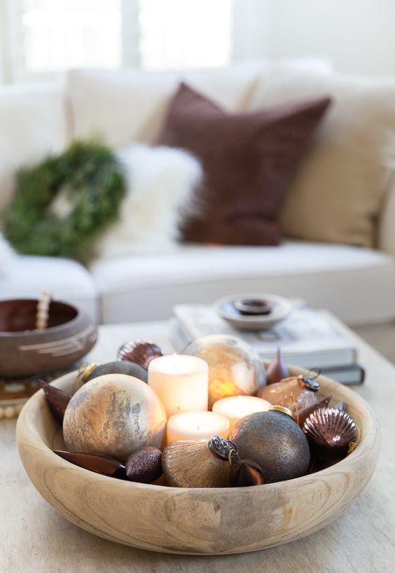 a cool modern Christmas arrangement with gold and burgundy ornaments and pillar candles is a chic and stylish idea