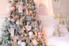a dreamy flocked Christmas tree decorated with blush, silver and pink ornaments, lights, stars and hearts