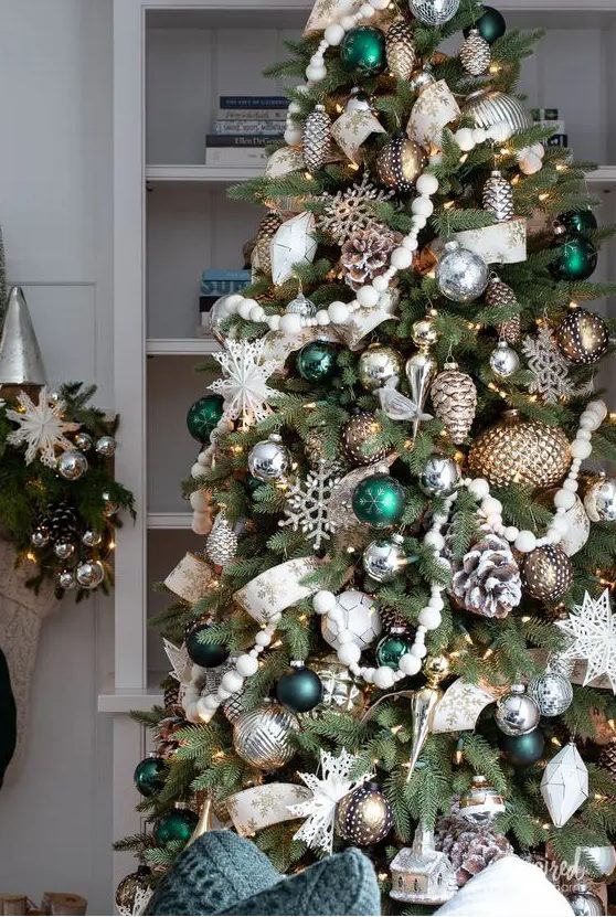 a fabulous Christmas tree with silver and metallic ornaments, bold green ones, bead garlands, snowy pinecones and snowflakes