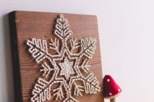 a fantastic white snowflake string art piece with thick yarn is a very eye-catchy decoration for the holidays
