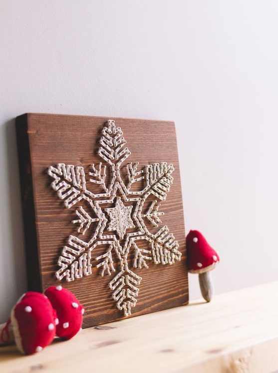 A fantastic white snowflake string art piece with thick yarn is a very eye catchy decoration for the holidays