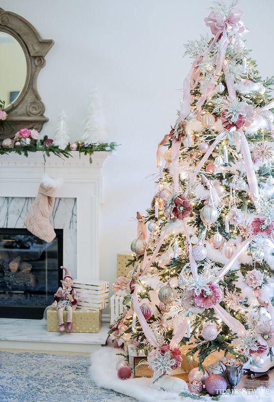 a flocked Christmas tree decorated with silver, blush and pink ornaments and faux blooms and ribbons
