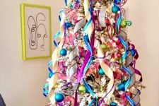 a flocked Christmas tree styled with pnk, green and blue ornaments and ribbons is a cool and bold idea to rock