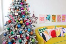 a flocked Christmas tree with bold ornaments of various kinds is a super cool and very fresh solution