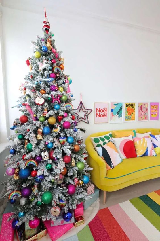 a flocked Christmas tree with bold ornaments of various kinds is a super cool and very fresh solution