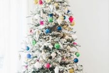 a flocked Christmas tree with colorful ornaments is a cool and catchy decoration to rock