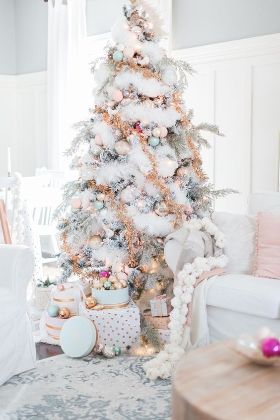 a flocked Christmas tree with faux snow garlands, tinsel, pastel ornaments looks absolutely adorable