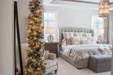 a flocked Christmas tree with lights and white ornaments plus a white tree skirt is a cool idea for a farmhouse space