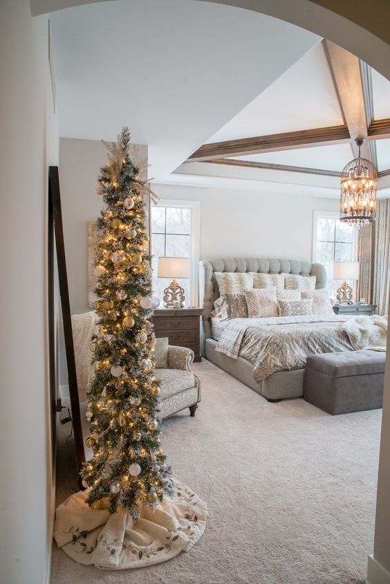 a flocked Christmas tree with lights and white ornaments plus a white tree skirt is a cool idea for a farmhouse space