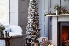 a flocked Christmas tree with lights, blue and white ornaments and a star topper is a cool and catchy idea