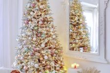 a flocked Christmas tree with metallic and pastel ornaments plus lights looks chic and soft