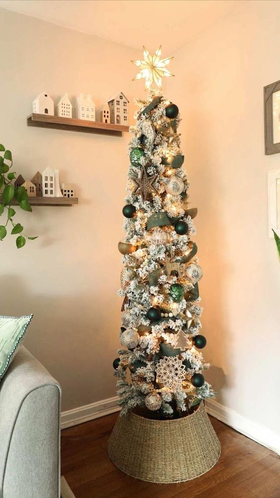 a flocked Christmas tree with ribbons, silver and dark green ornaments, snowflakes, lights and stars