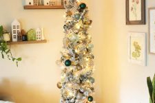 a flocked pencil Christmas tree with silver, gold and dark green ornaments, lights and plaid ribbons